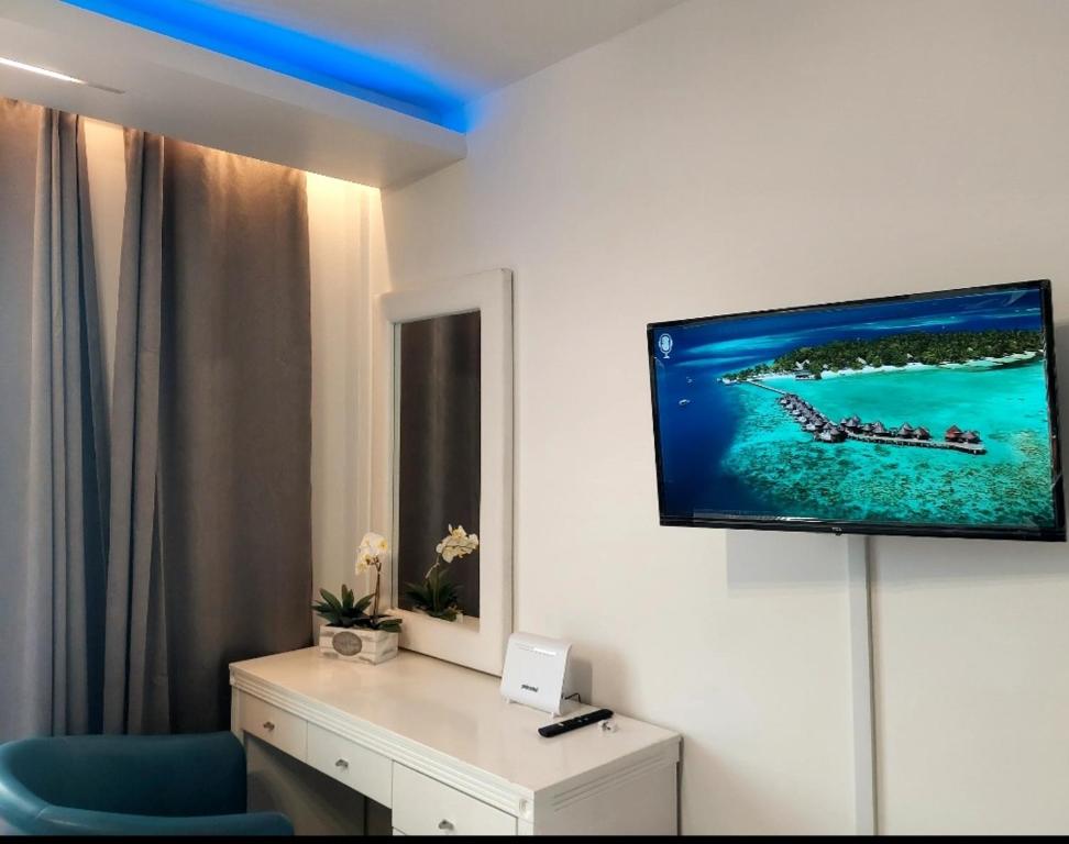 Una habitación con un televisor en una pared con una silla azul. en Luxury Apartment No. 202 (Napa Ace), en Ayia Napa