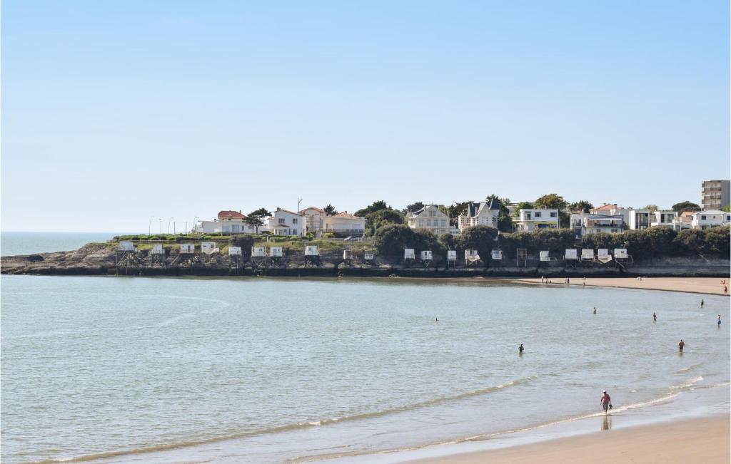 a beach with people in the water and houses at Stunning Home In Saint-palais-sur-mer With Wifi And 6 Bedrooms in Saint-Palais-sur-Mer