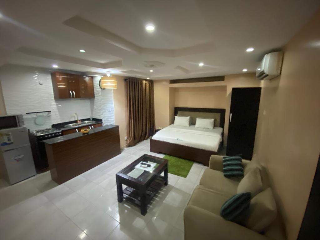 um quarto com uma cama, um sofá e uma cozinha em Studio B, (Studio Apartment) Hillside Gardens em Lagos