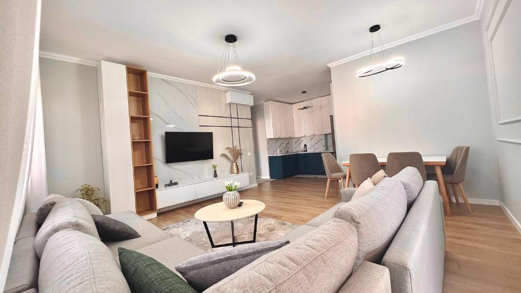een woonkamer met een bank en een eetkamer bij Zeus Tirana Suite in Tirana