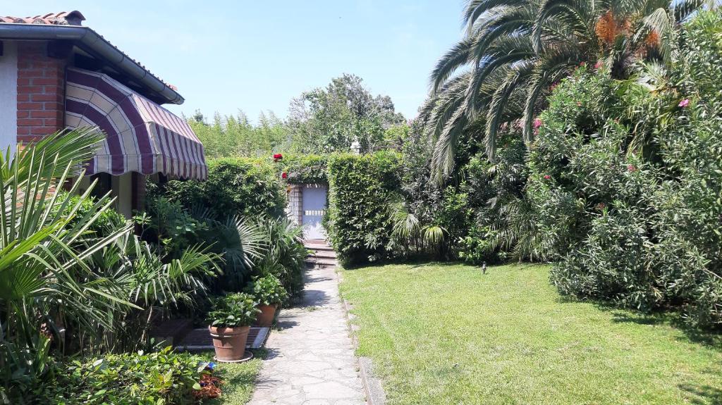 a garden with plants and trees and a house at APARTMA ERNESTINO in Portorož