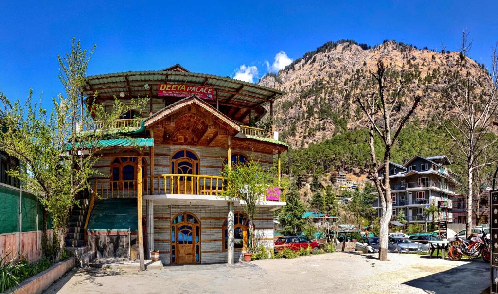 a wooden building in front of a mountain at Diya Palace Kasol in Kasol