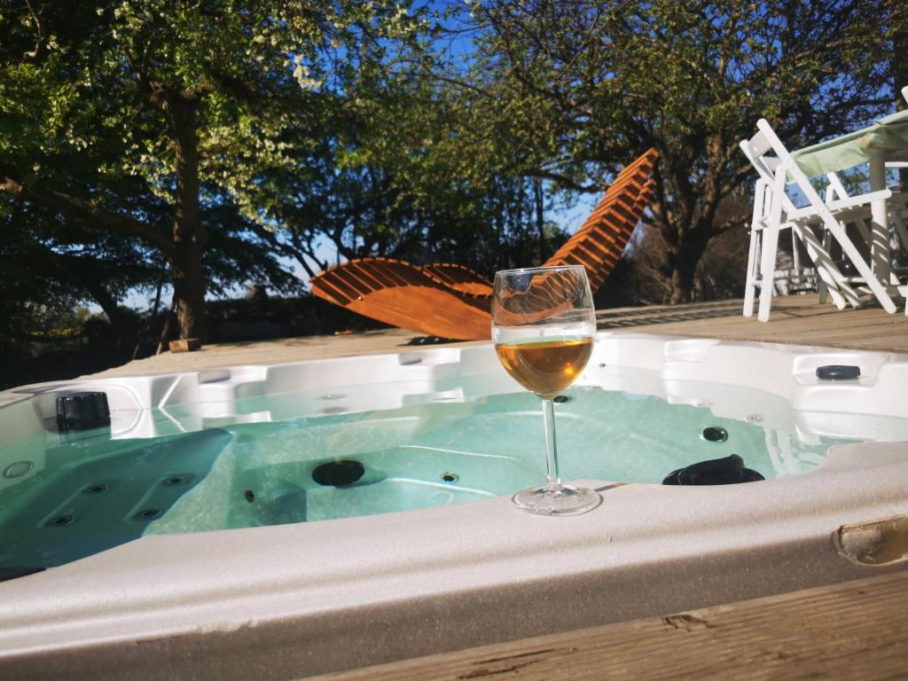 een glas wijn op een tafel naast een hot tub bij Yogi Wellness Guesthouse in Klagstorp