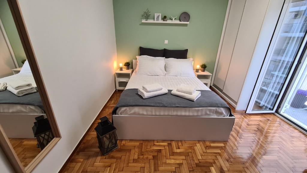 1 dormitorio pequeño con 1 cama y 2 espejos en Dunant Studio en Athens