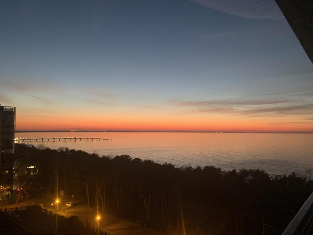 a view of the ocean at sunset from a building at Meerblick Appartement Hochbett Küche Boxspringbett MM in Międzyzdroje