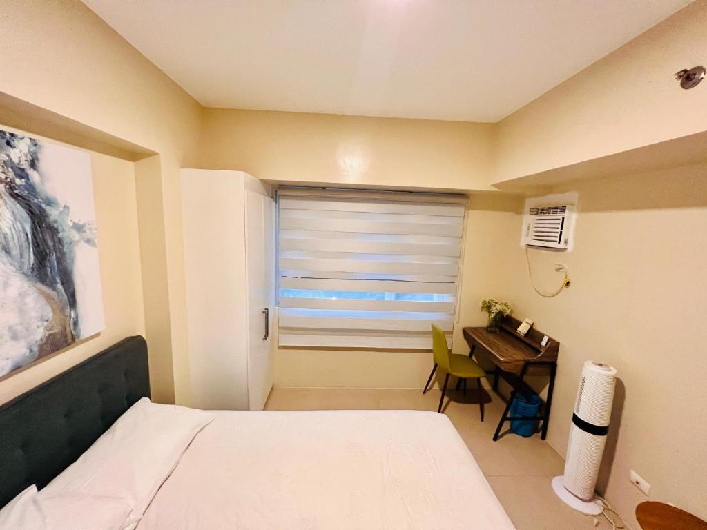 a bedroom with a bed and a desk and a window at * * *H Incomparable Value in Iloilo City