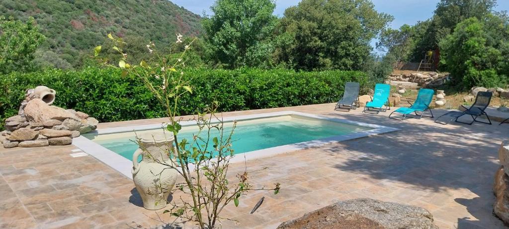 una piscina con sillas y un jarrón en un patio en Villa de charme, en Urtaca