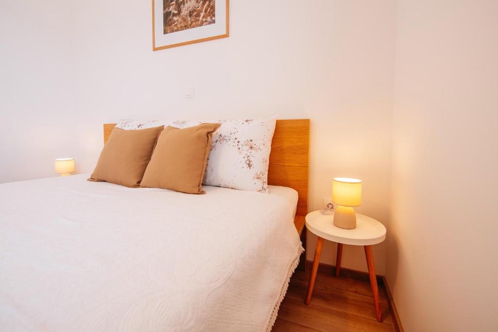 um quarto com uma cama e uma mesa com 2 candeeiros em Rock Apartments II em Novalja