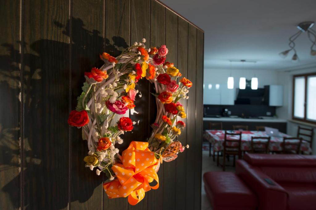 Una corona de flores está colgada en una pared en Casa vacanza Simona, en Salionze