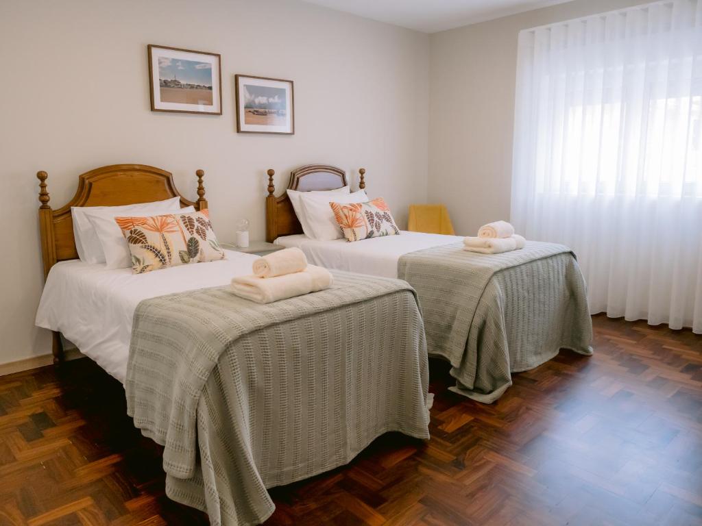 a bedroom with two beds with towels on them at Pontes Guest House in Arcozelo