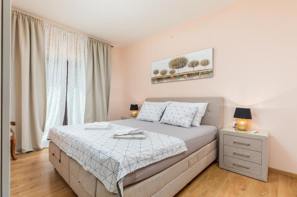 a bedroom with a large bed and a window at Apartman Darija in Vodnjan
