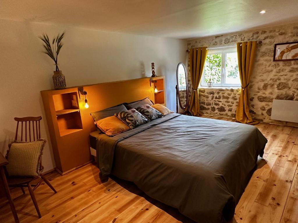 - une chambre avec un grand lit et une fenêtre dans l'établissement Naturo-gites, à Nieul-le-Virouil