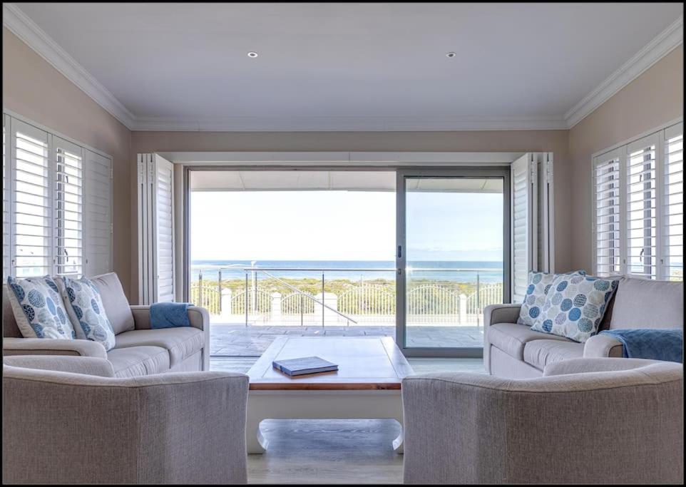 a living room with two couches and a view of the ocean at Seafront Retreat in Sandbaai in Hermanus