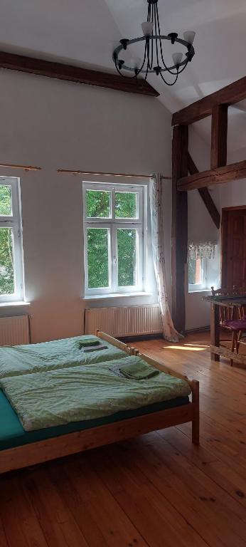 a bedroom with a bed in a room with windows at Dom na Mazurach Pilec in Pilec