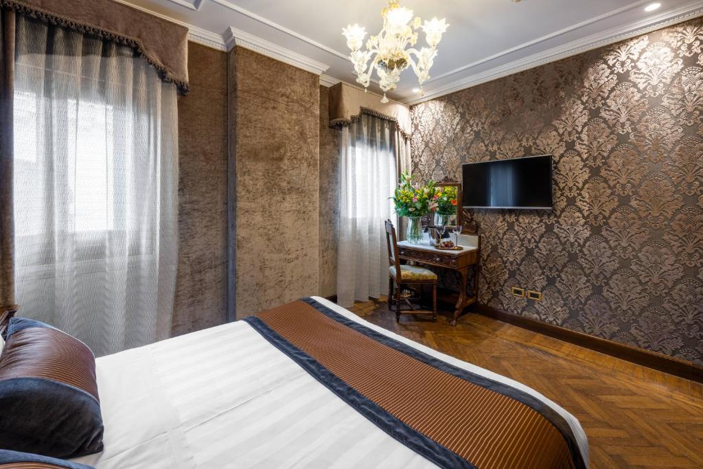 a bedroom with a bed and a tv on a wall at Palazzo Bembo - Exclusive Accommodation in Venice