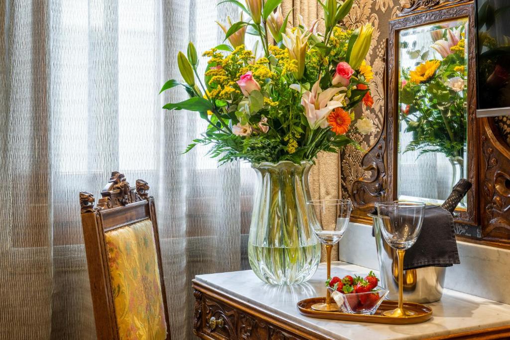 a vase of flowers sitting on top of a table at Palazzo Bembo - Exclusive Accommodation in Venice