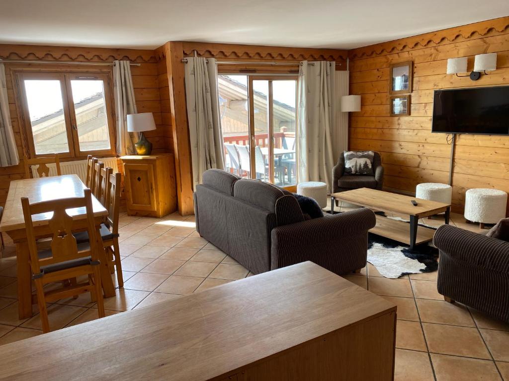 een woonkamer met banken en een tafel en een televisie bij Tignes-8-10 personnes-4 chambres-parking in Tignes