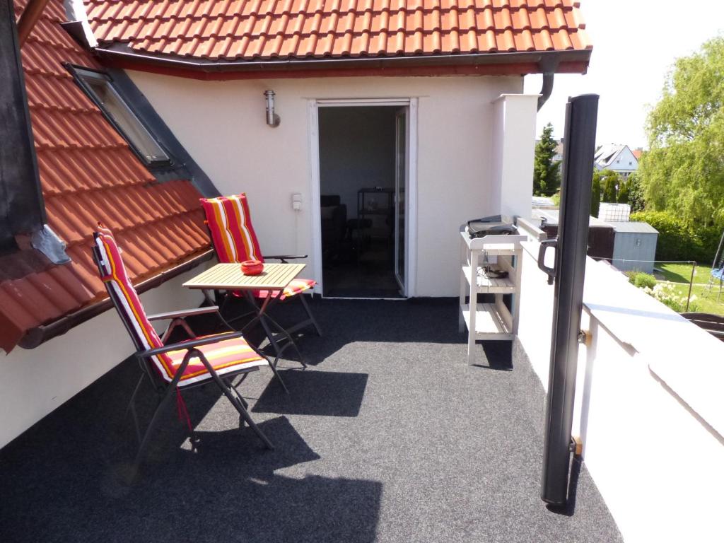 a patio with two chairs and a table on a house at Ferienwohnung in Porta Westfalica