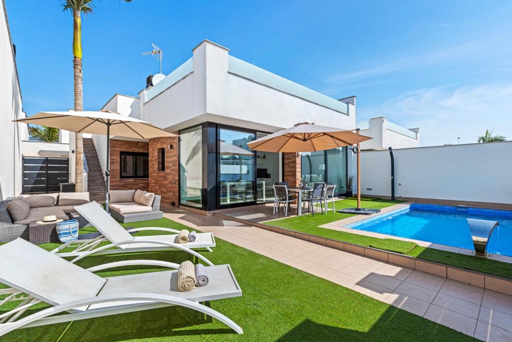 a villa with a swimming pool and a house at Mar Menor in Lo Pagán