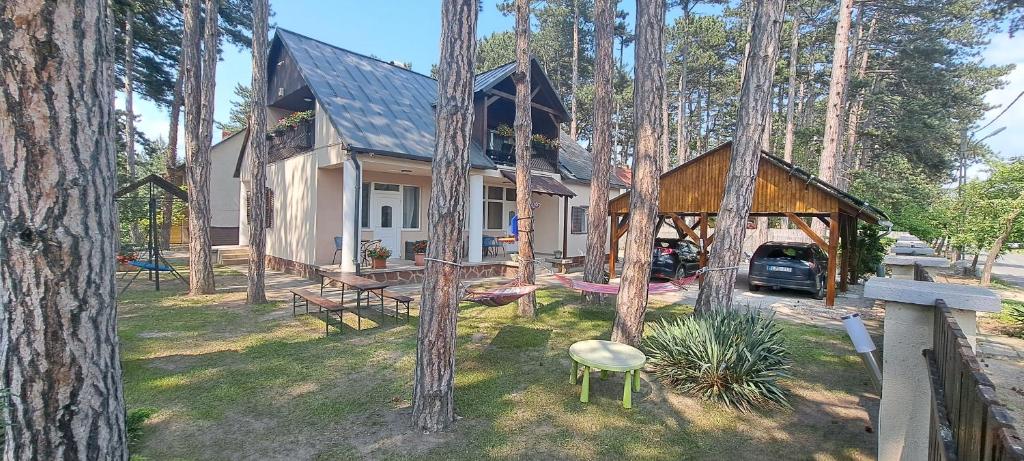 una casa nel bosco con un tavolo da picnic nel cortile di Mary Villa a Siófok