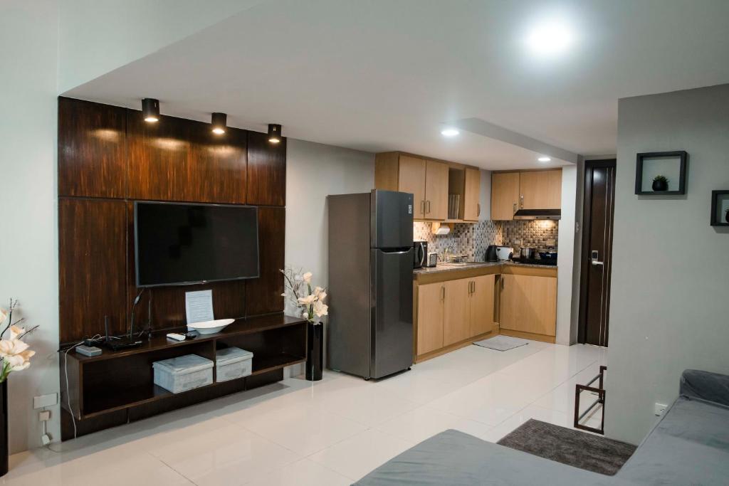 a kitchen with a refrigerator and a tv in it at Renovated - City Center - Pool Access - 2 A/Cs in Cebu City