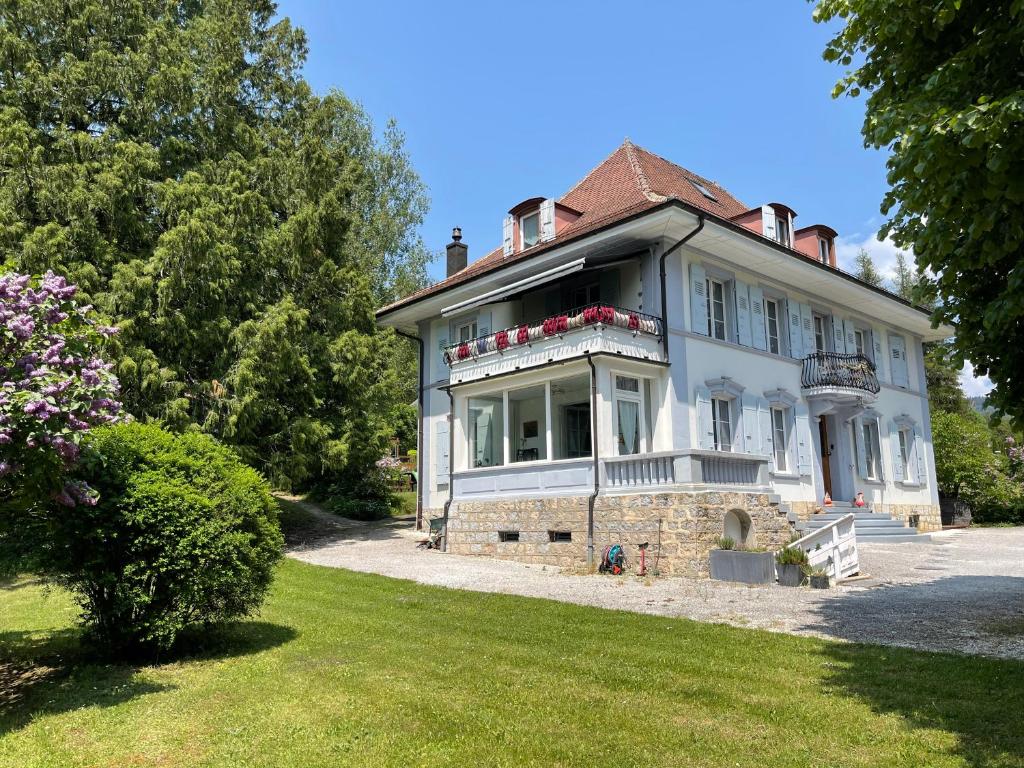 a large white house with a large yard at Appartement de standing à Vallorbe in Vallorbe