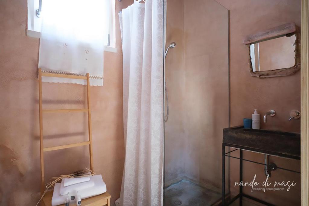 a bathroom with a shower curtain and a sink at Masseria Giangrande - Rooms and Apartment in Polignano a Mare