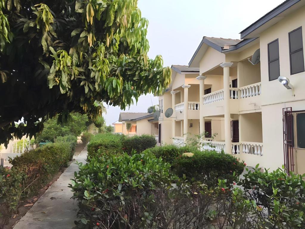 a row of apartment buildings with a pathway at Lord's Hands Guesthouse Hotel in Winneba