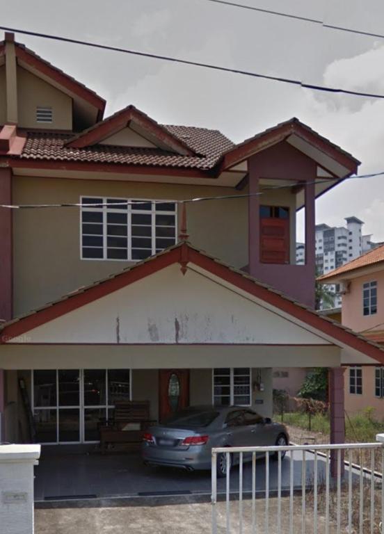 een huis met een auto geparkeerd op een parkeerplaats bij D' Terengganu Homestay in Kuala Terengganu