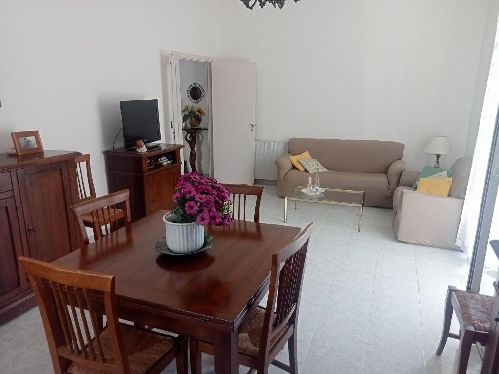 Monte Rubiaglio的住宿－Civico 5，客厅配有带鲜花的木桌