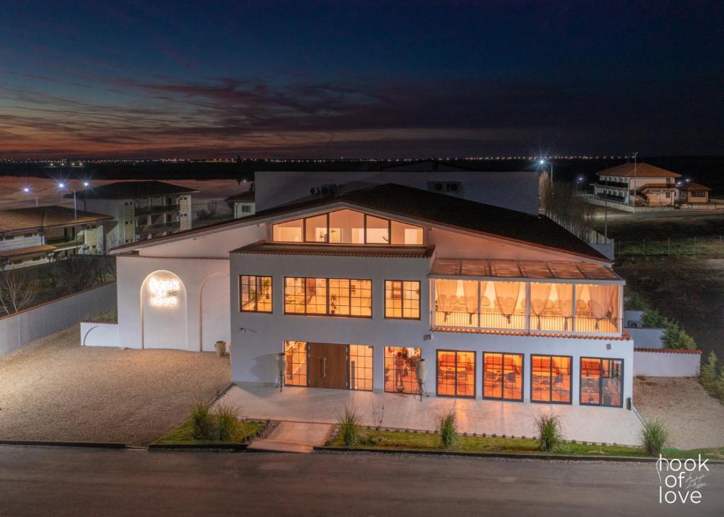 een groot huis 's nachts met de lichten aan bij Hook Of Love - Le Mirage de la Mer in Olimp