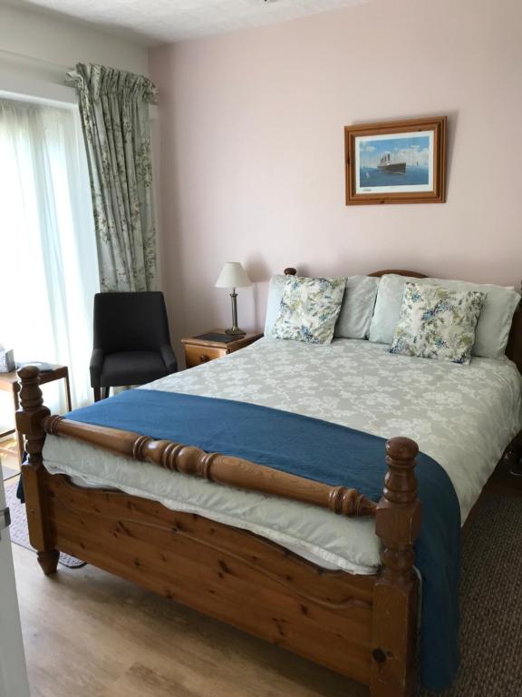 um quarto com uma cama grande e um cobertor azul em Lilac Villa Guest House em Weymouth