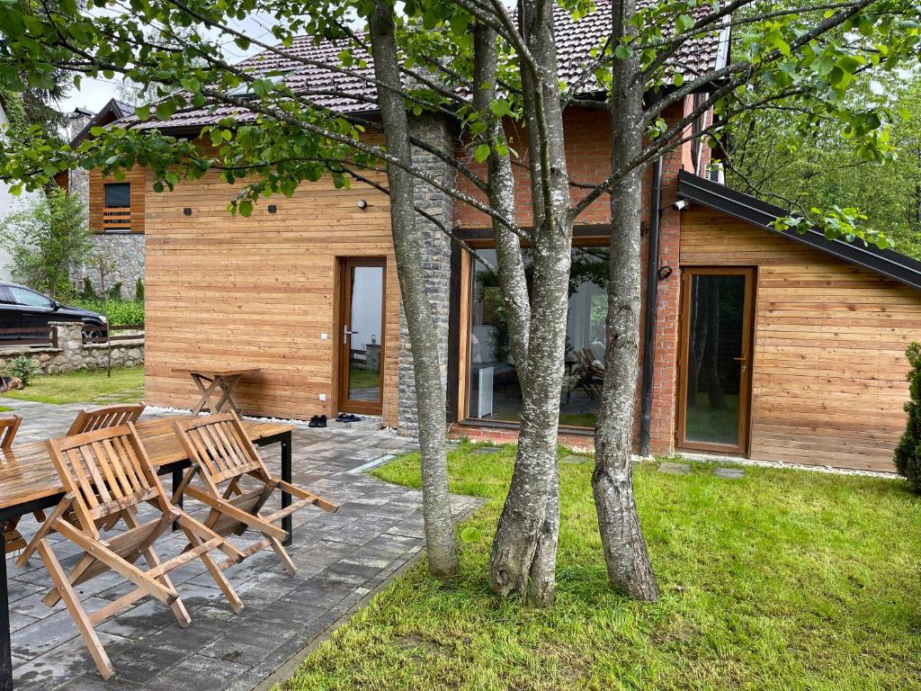 un patio con 2 bancos de madera y una casa en Villa Alpina Brezovice en Brezovica