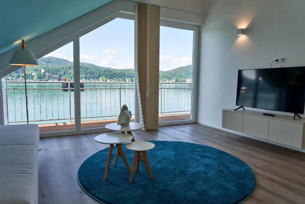 sala de estar con vistas panorámicas al agua en Appartements am See en Maria Wörth