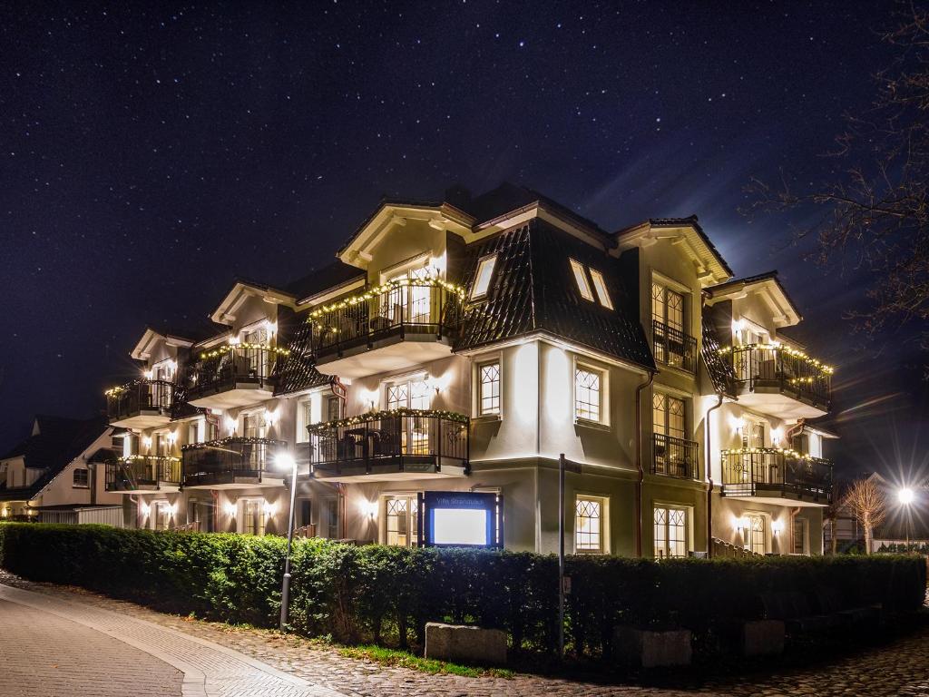 ein großes weißes Gebäude mit Balkon in der Nacht in der Unterkunft Villa Strandblick Zingst in Zingst