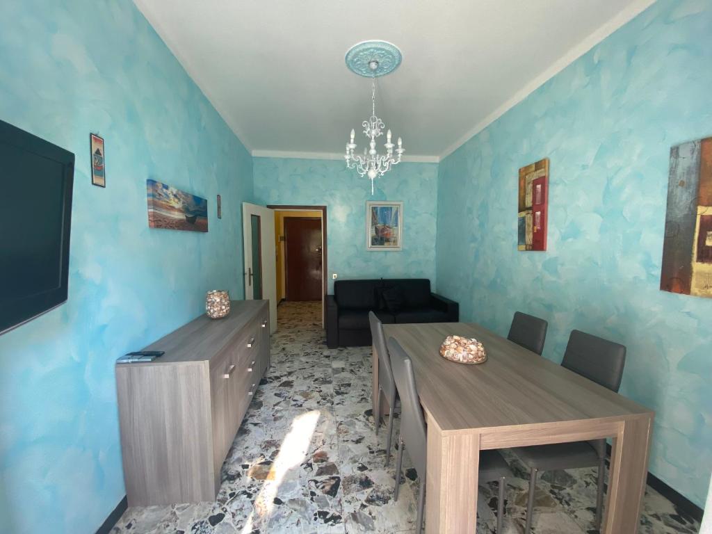 sala de estar con paredes azules, mesa y sillas en Viale Hanbury, en Alassio