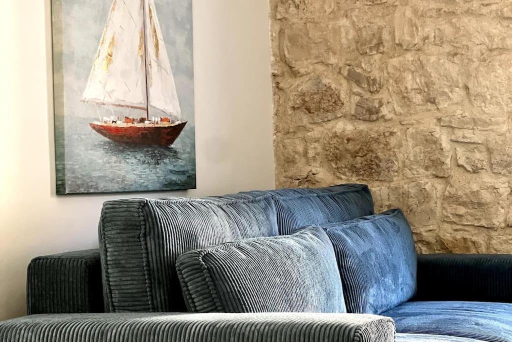 a couch in a living room with a sail boat on the wall at Sailor's apartment in Supetar