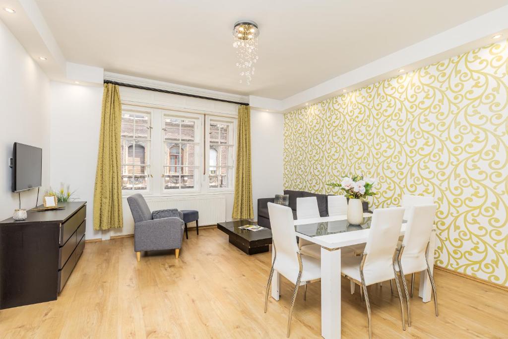 a living room with a dining table and chairs at Real Apartments Kertész in Budapest