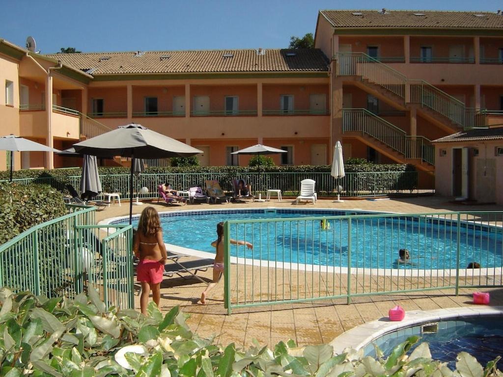 2 enfants debout à côté d'une piscine dans l'établissement Grazioso bilocale a 200 m dal mare in residence con piscina e WI-FI, à Linguizzetta