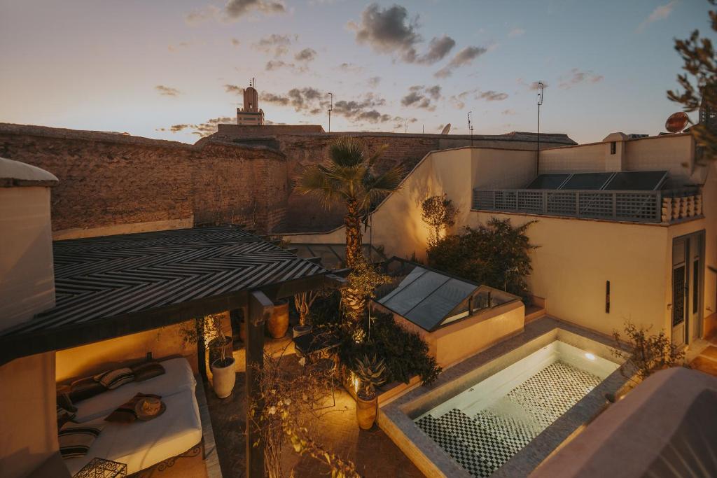 馬拉喀什的住宿－Riad Les Hirondelles Boutique Hotel，享有带游泳池的大楼的顶部景致