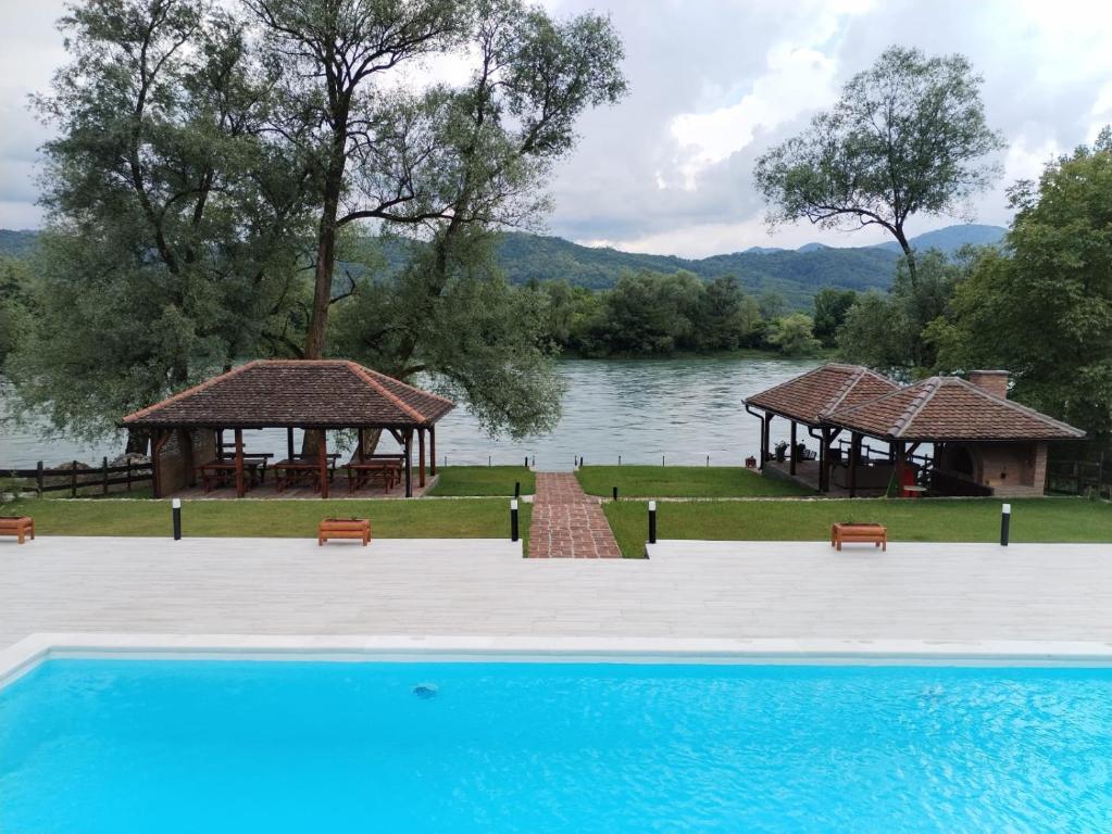 a swimming pool with a view of a lake at Tri vrbe in Ljubovija