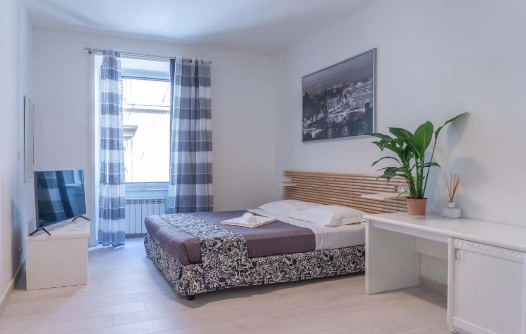 1 dormitorio con 1 cama, escritorio y TV en Le suite di Borgo en Roma