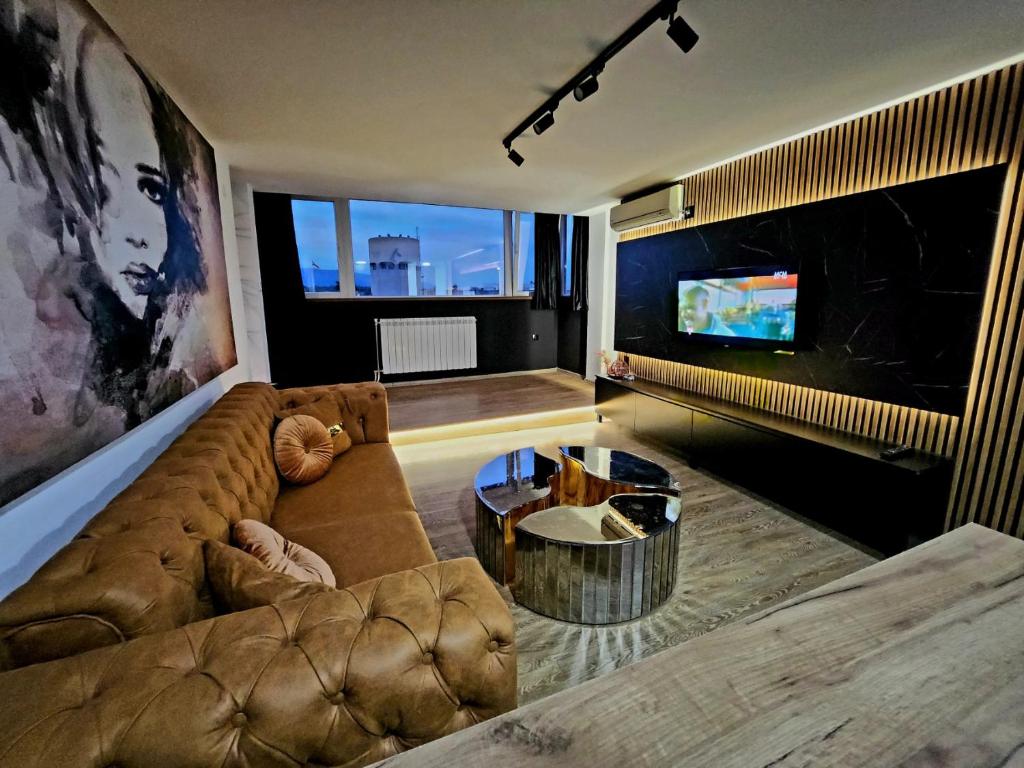 a living room with a couch and a tv at ELISA Rooftop Luxury Apartments in Skopje