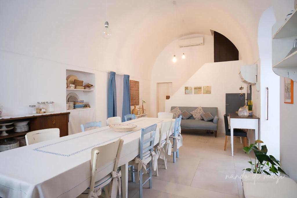 a dining room with white tables and chairs at Masseria Giangrande - Rooms and Apartment in Polignano a Mare