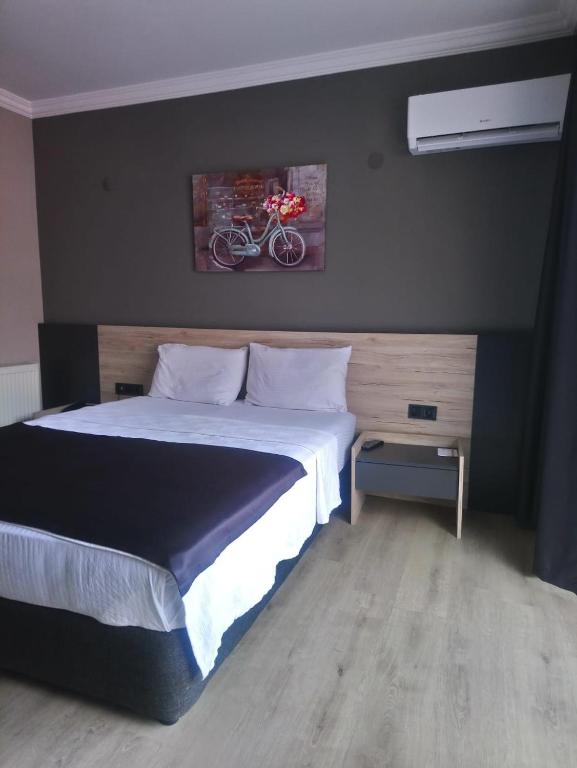 a bedroom with a bed and a picture of a bike on the wall at Grand Faik Hotel in Çeşme