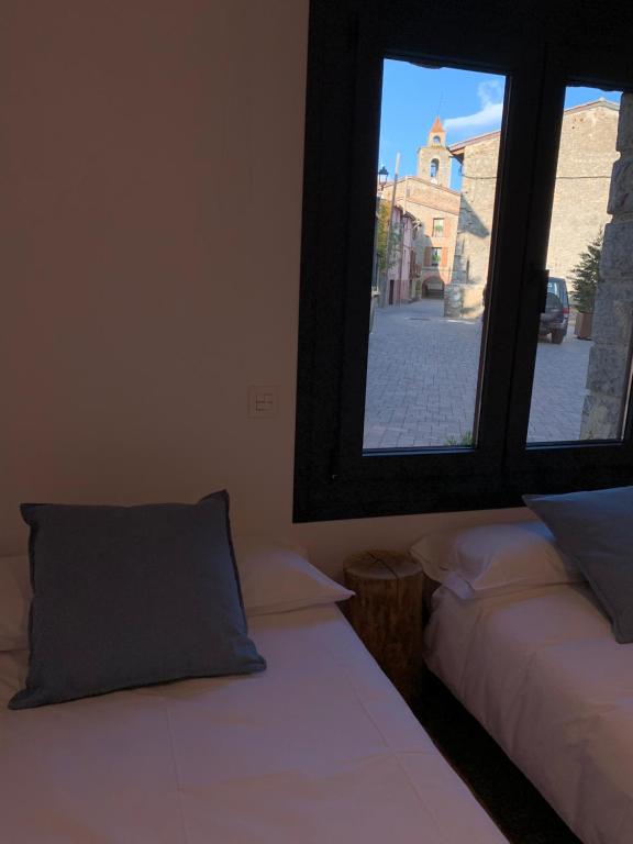 a room with two beds and a window at CAL JAN - La Muralla in Bellver de Cerdanya 