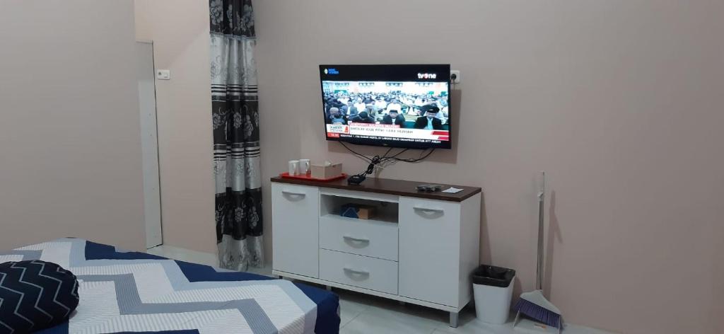 sala de estar con TV y tocador blanco en Homestay ZRMA Palu, en Palu