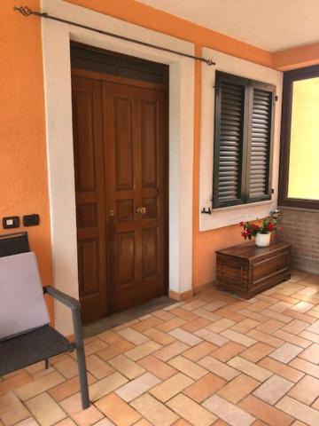 a house with a door and a chair and a window at Il giardino delle rose in Spello