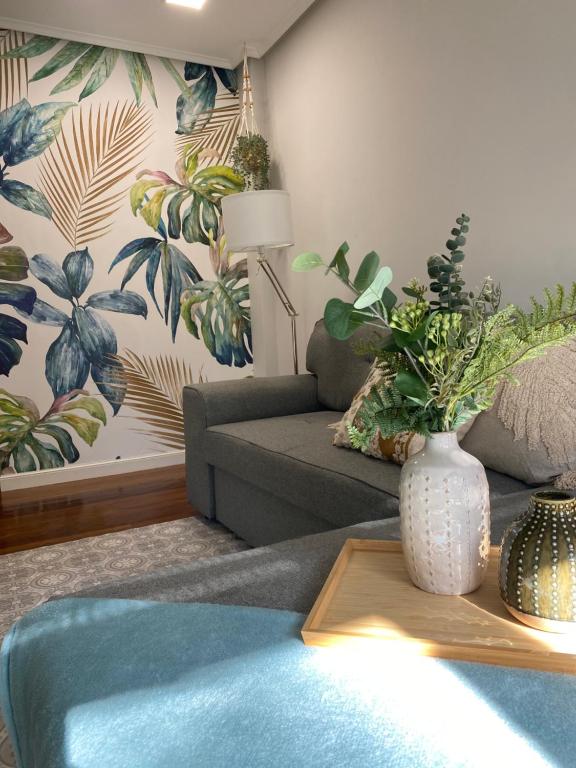uma sala de estar com um sofá e um vaso sobre uma mesa em Apartamento Playa Ostende ,Garaje incluido em Castro-Urdiales