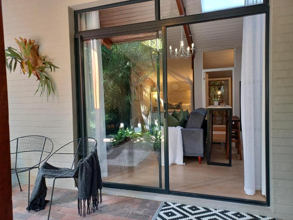 a sliding glass door on a patio with a table and chairs at Eggersheim in Pinetown